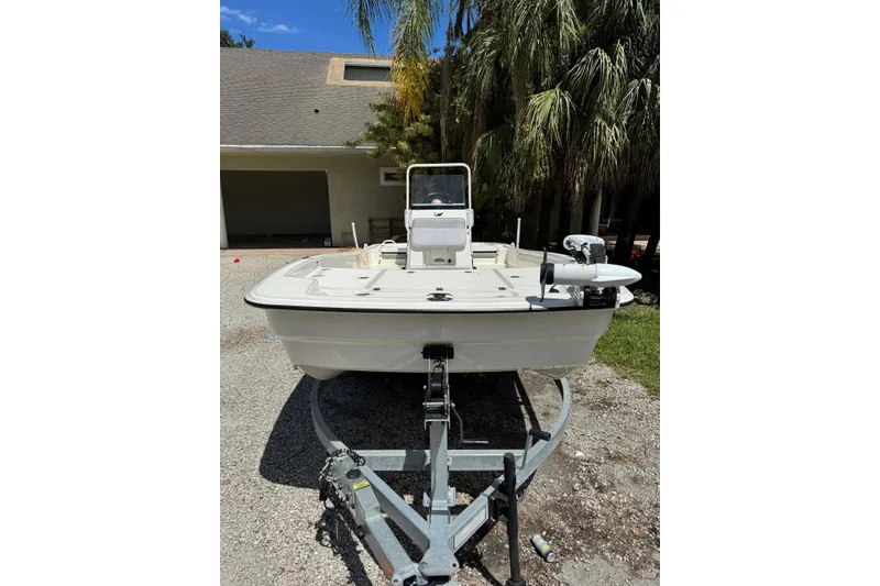 Slide: The Image of 2025 Mako Pro Skiff 19 CC boat on trailer, parked outdoors near palm trees. - 14