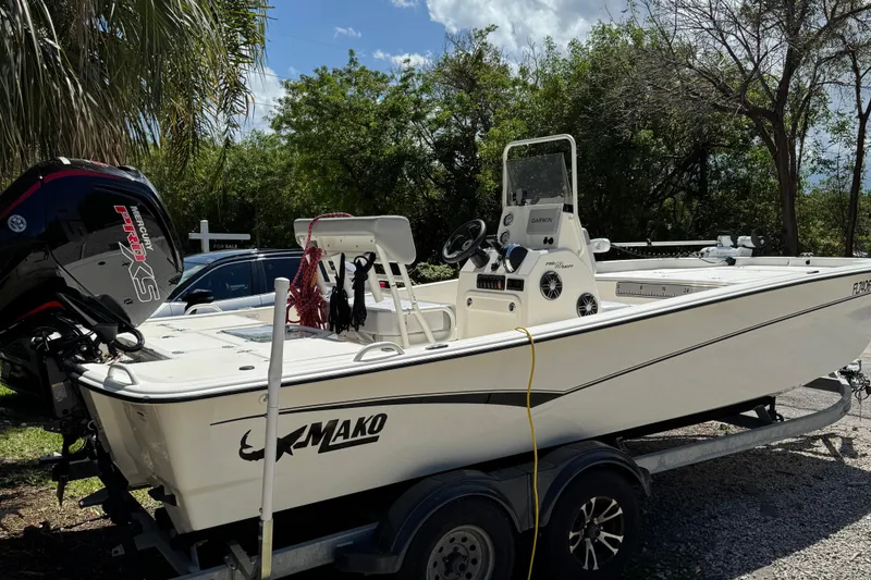 Slide: The Image of 2025 Mako Pro Skiff 19 CC boat on trailer, parked outdoors under sunny skies. - 17