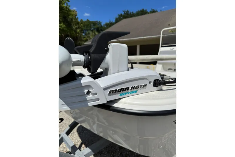 Slide: The Image of 2025 Mako Pro Skiff 19 CC with Minn Kota Riptide motor, parked outdoors. - 18