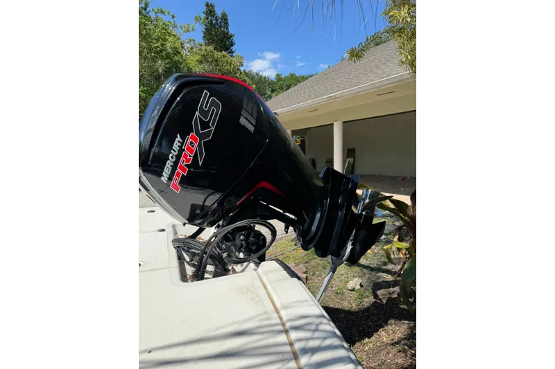 Slide: The Image of 2025 Mako Pro Skiff 19 CC with Mercury Pro XS outboard motor in a sunny setting. - 19