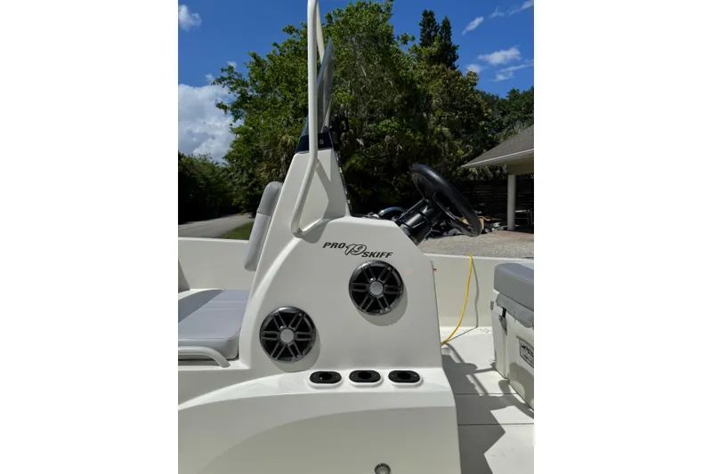 Slide: The Image of 2025 Mako Pro Skiff 19 CC boat console with steering wheel and speakers. - 23