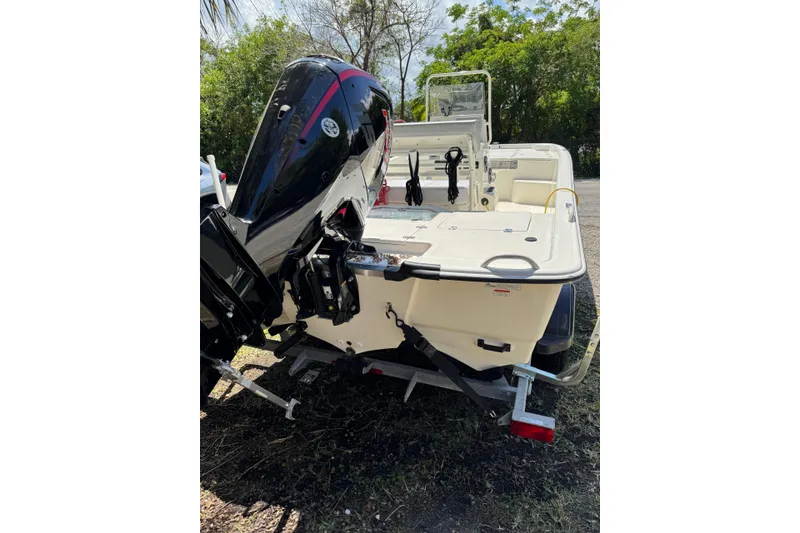 Slide: The Image of 2025 Mako Pro Skiff 19 CC boat with outboard motor, parked on a trailer. - 9