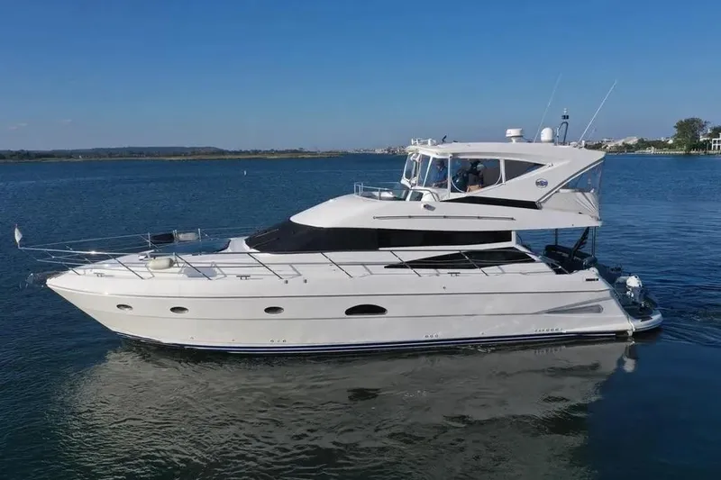 The Image of 2005 Neptunus 56 Flybridge yacht cruising on calm waters under clear blue skies. - 0