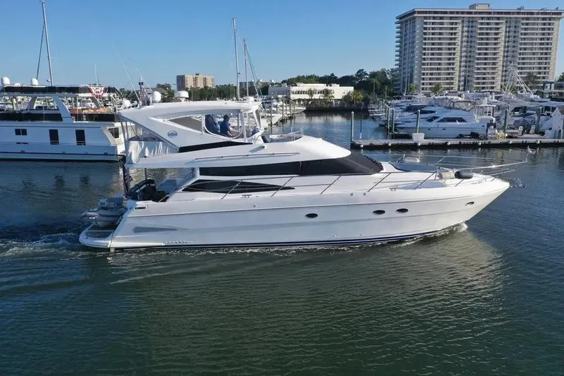 Slide: The Image of 2005 Neptunus 56 Flybridge yacht cruising in a marina with cityscape background. - 12