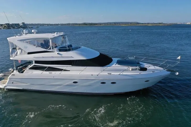 Slide: The Image of 2005 Neptunus 56 Flybridge yacht cruising on calm waters under clear skies. - 13