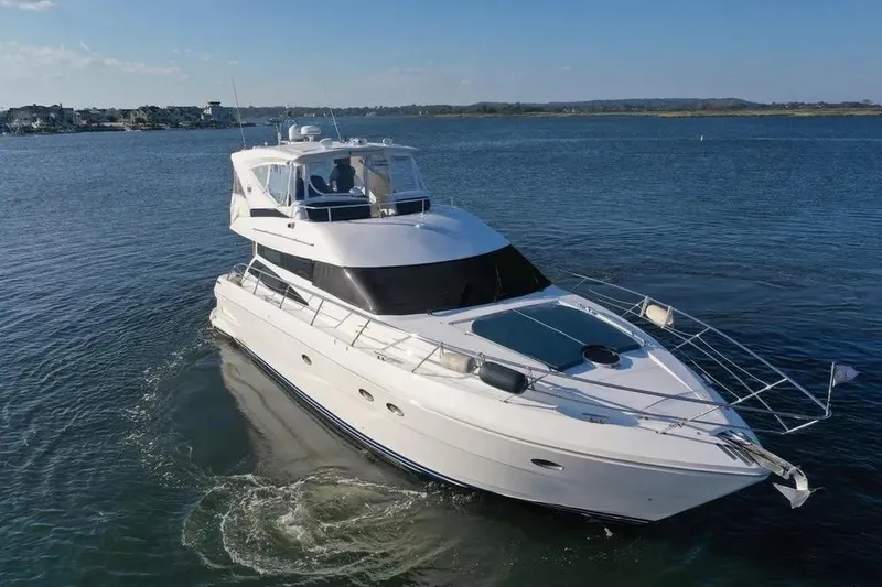 Slide: The Image of 2005 Neptunus 56 Flybridge yacht cruising on calm waters under clear skies. - 14