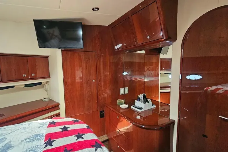 Slide: The Image of Luxurious 2005 Neptunus 56 Flybridge yacht interior with polished wood cabinetry and mounted TV. - 19