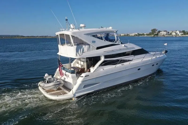 Slide: The Image of 2005 Neptunus 56 Flybridge yacht cruising on a serene blue waterway. - 3