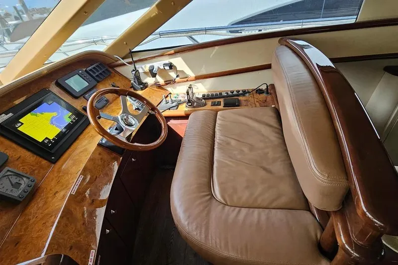 Slide: The Image of Luxurious 2005 Neptunus 56 Flybridge yacht helm with leather seating and navigation controls. - 44