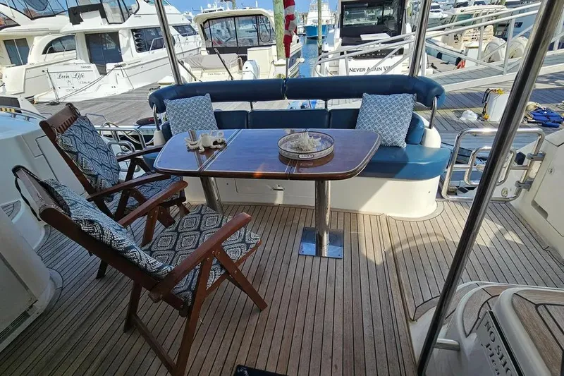 Slide: The Image of Luxurious 2005 Neptunus 56 Flybridge yacht deck with elegant seating and table setup. - 46