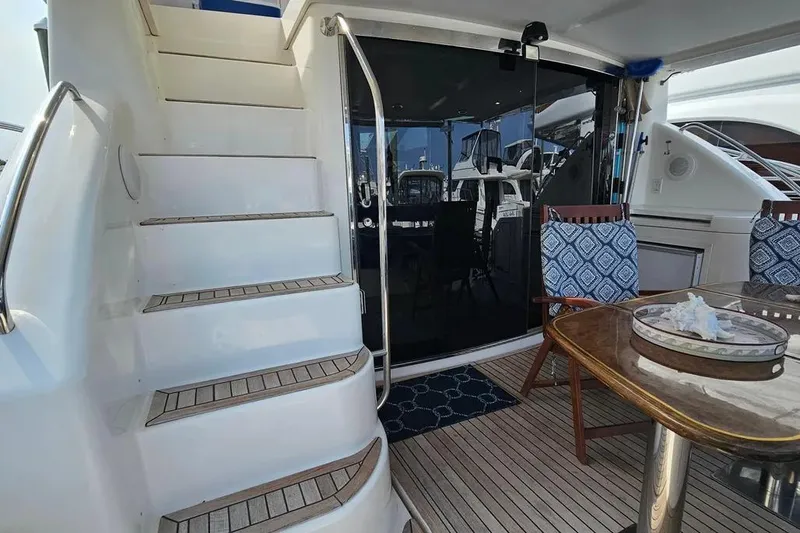 Slide: The Image of 2005 Neptunus 56 Flybridge yacht with outdoor seating and staircase to upper deck. - 49