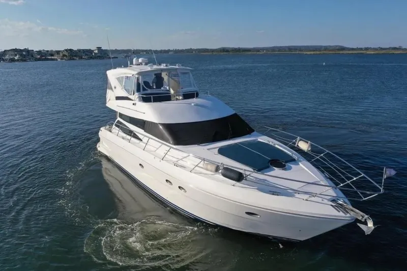 Slide: The Image of 2005 Neptunus 56 Flybridge yacht cruising on calm waters under clear skies. - 6