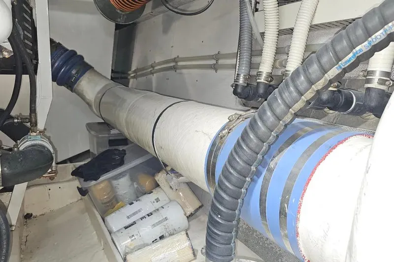 Slide: The Image of Engine room of a 2005 Neptunus 56 Flybridge yacht, showcasing pipes and storage. - 73