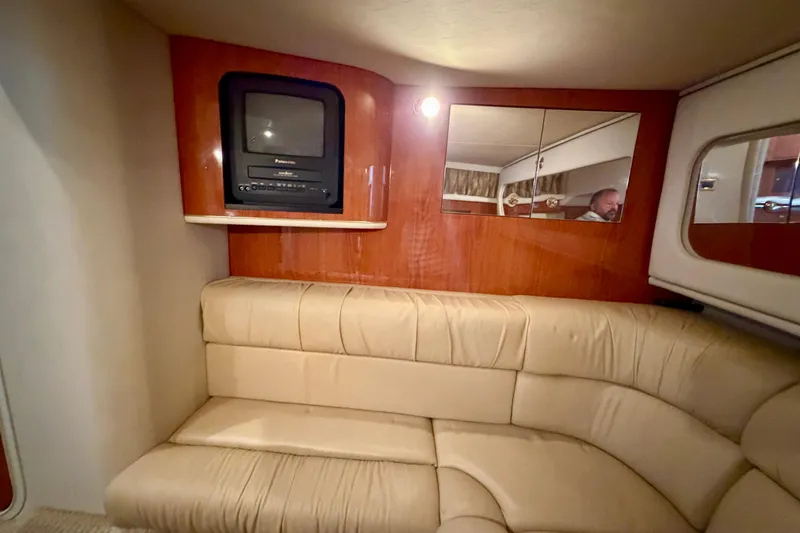Slide: The Image of Interior of 2001 Sea Ray 410 Sundancer with beige leather seating and built-in TV. - 14