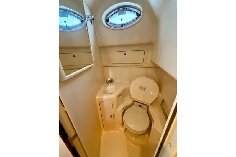 Slide: The Image of 2001 Sea Ray 410 Sundancer bathroom with toilet, sink, and mirror. - 16