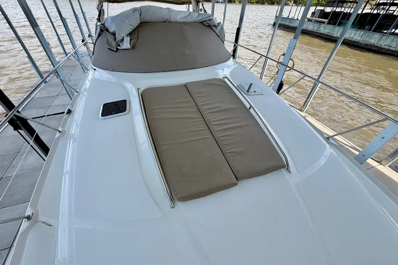 Slide: The Image of 2001 Sea Ray 410 Sundancer yacht with cushioned deck, docked by the water. - 20