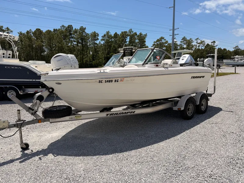 Slide: The Image of 2011 Triumph 191 FS boat parked on trailer outdoors. - 3