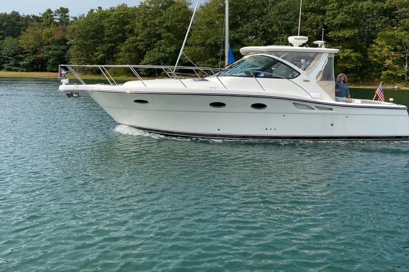 The Image of 2006 Tiara Yachts 3200 Open cruising on a serene lake with lush green surroundings. - 0