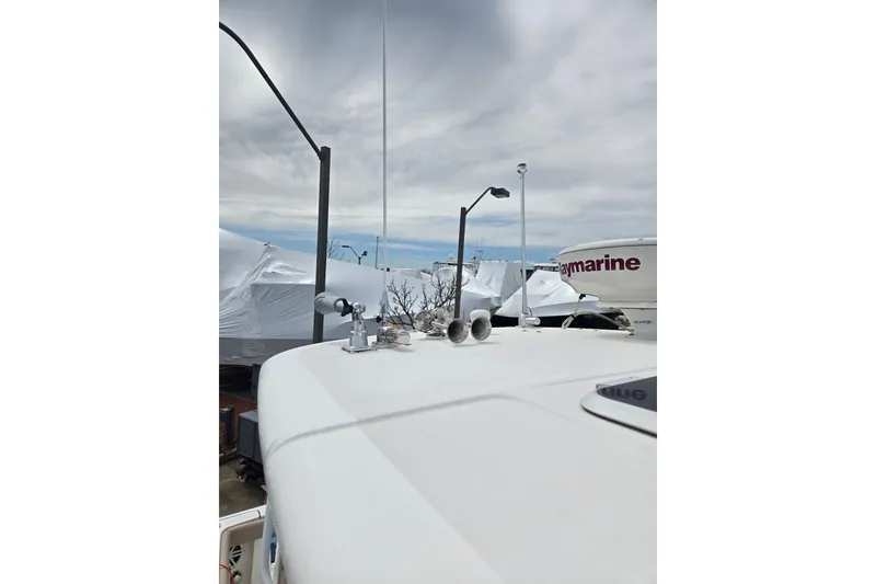 Slide: The Image of 2006 Tiara Yachts 3200 Open, docked with covered boats in background, overcast sky. - 13