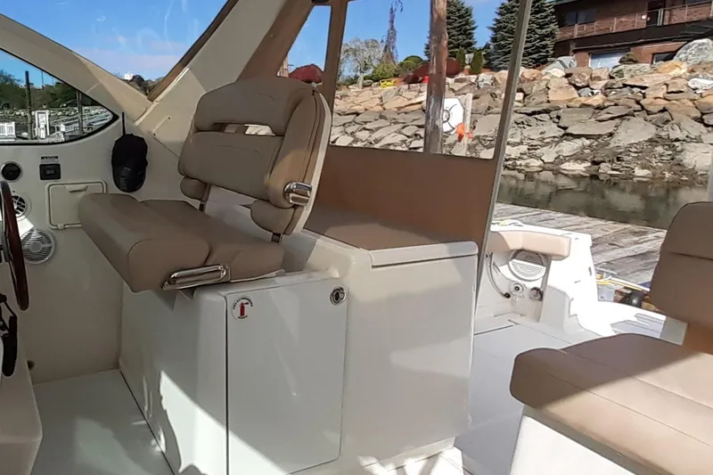 Slide: The Image of Interior of a 2006 Tiara Yachts 3200 Open, featuring beige seating and helm area. - 21