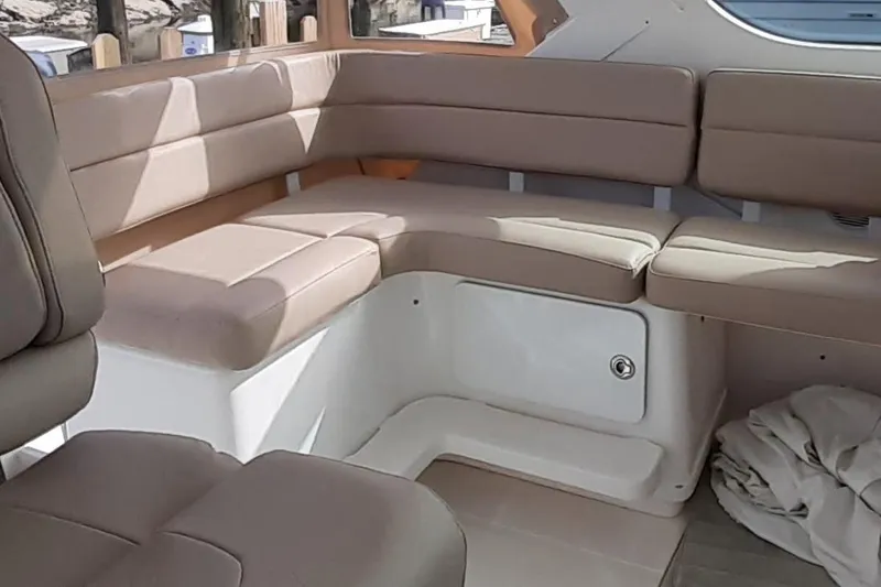 Slide: The Image of Interior seating of 2006 Tiara Yachts 3200 Open, featuring beige cushioned benches. - 23