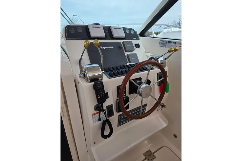 Slide: The Image of Helm of 2006 Tiara Yachts 3200 Open with Raymarine electronics and wooden steering wheel. - 24