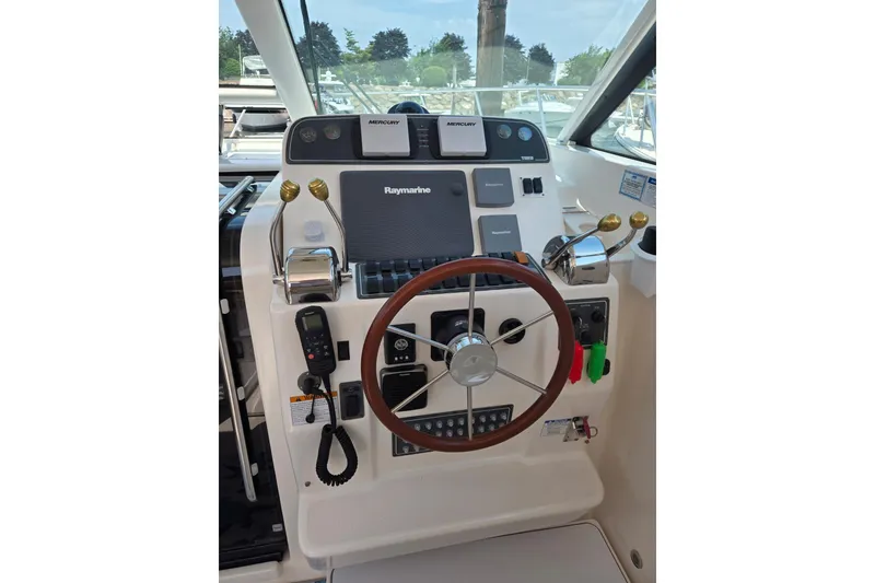 Slide: The Image of Helm of 2006 Tiara Yachts 3200 Open with Raymarine navigation system and wooden steering wheel. - 25