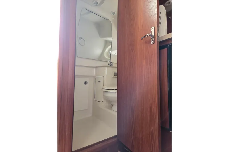 Slide: The Image of 2006 Tiara Yachts 3200 Open bathroom with wooden door and compact design. - 28