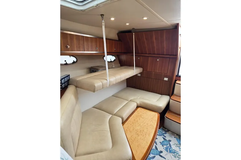 Slide: The Image of Interior of 2006 Tiara Yachts 3200 Open with beige seating and wooden cabinetry. - 32
