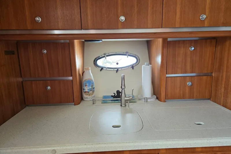 Slide: The Image of 2006 Tiara Yachts 3200 Open galley with wooden cabinets and a sleek countertop. - 38