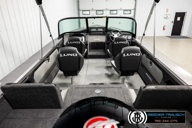Slide: The Image of 2026 Lund 1875 Tyee boat interior with seating and steering wheel in showroom. - 12