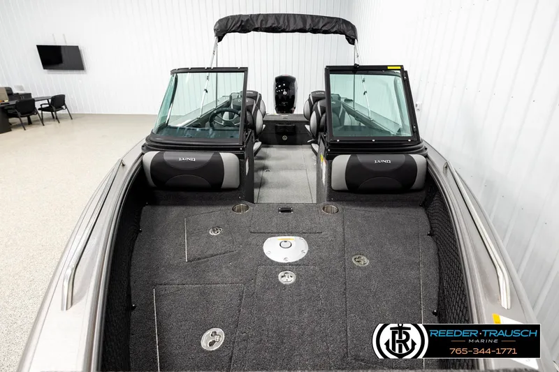 Slide: The Image of 2026 Lund 1875 Tyee boat interior with seating and windshield in showroom. - 15