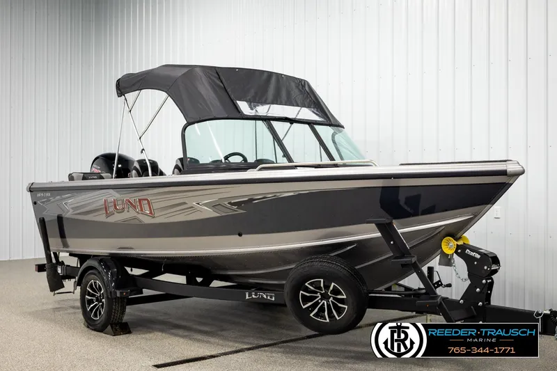 Slide: The Image of 2026 Lund 1875 Tyee boat on trailer, displayed indoors at Reeder-Trausch Marine. - 3