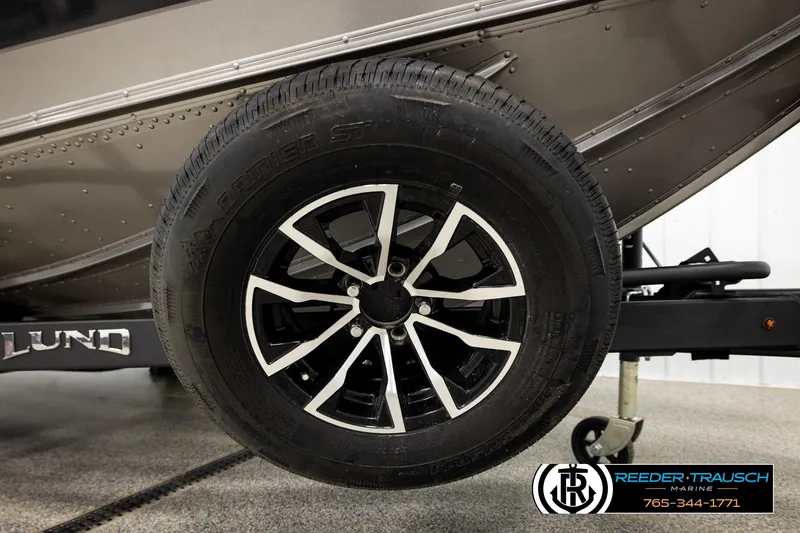 Slide: The Image of 2026 Lund 1875 Tyee boat trailer wheel, featuring sleek black and silver design. - 52