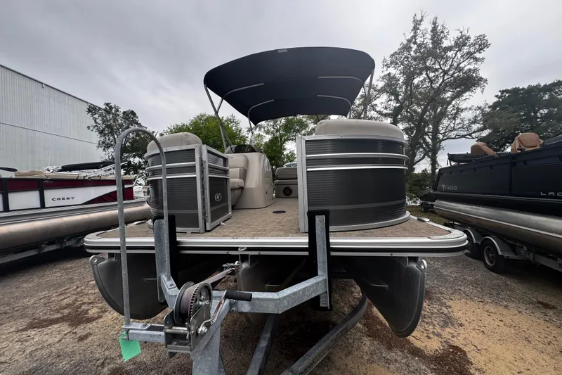 Slide: The Image of 2020 Harris Cruiser 210 pontoon boat on trailer, parked outdoors under cloudy sky. - 9