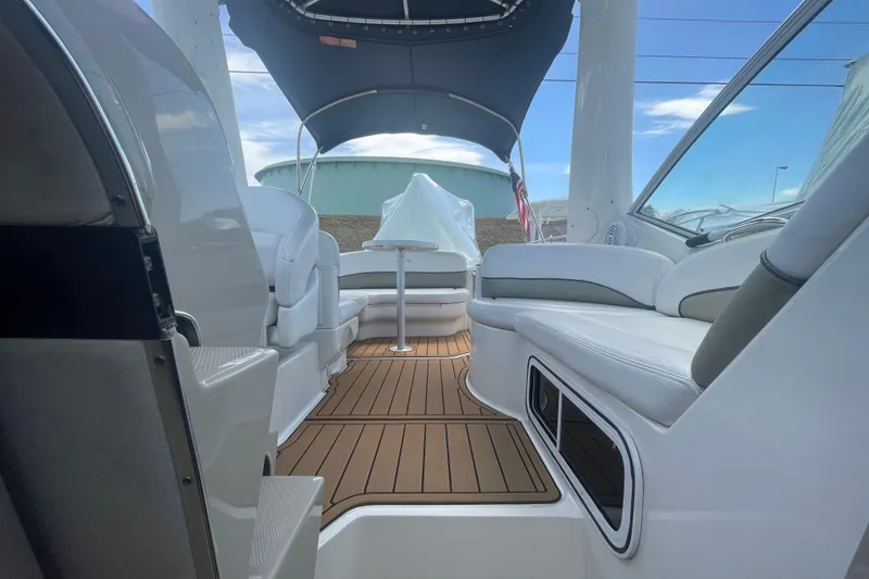 Slide: The Image of 2007 Sea Ray Sundancer 260 interior with seating and wooden deck under a canopy. - 11
