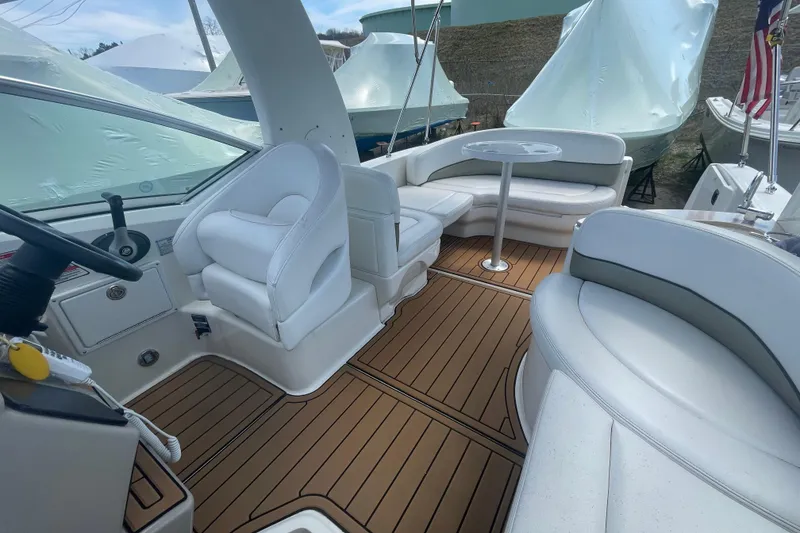 Slide: The Image of 2007 Sea Ray Sundancer 260 interior with white seating and wood-style flooring. - 12
