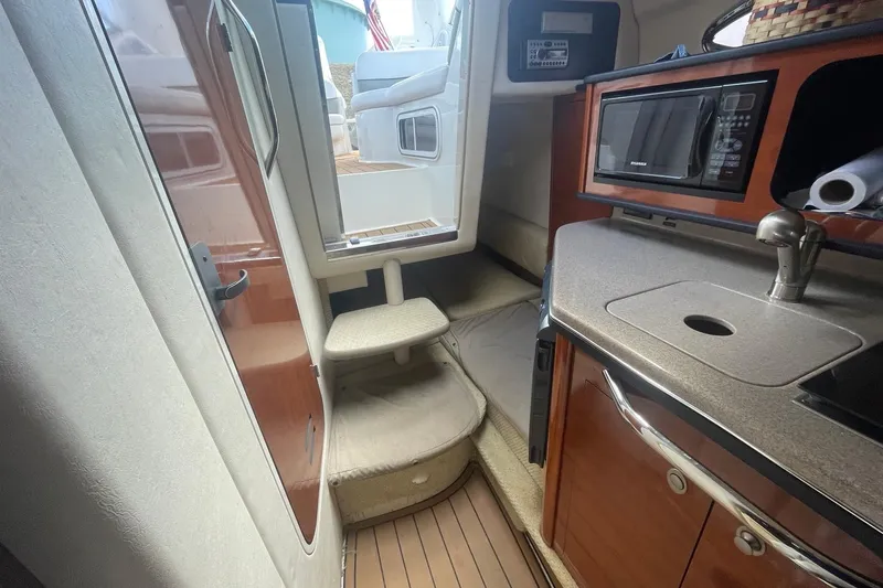 Slide: The Image of 2007 Sea Ray Sundancer 260 interior with kitchenette and stairs to deck. - 13