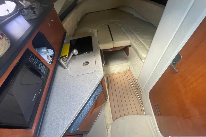 Slide: The Image of Interior of 2007 Sea Ray Sundancer 260, featuring kitchenette and cozy sleeping area. - 14