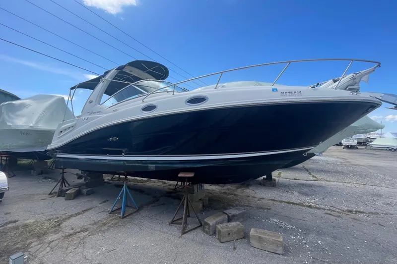 Slide: The Image of 2007 Sea Ray Sundancer 260 boat on stands, blue hull, clear sky background. - 4