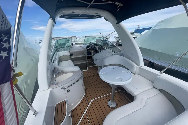 Slide: The Image of 2007 Sea Ray Sundancer 260 boat interior with seating and table, docked under blue sky. - 7