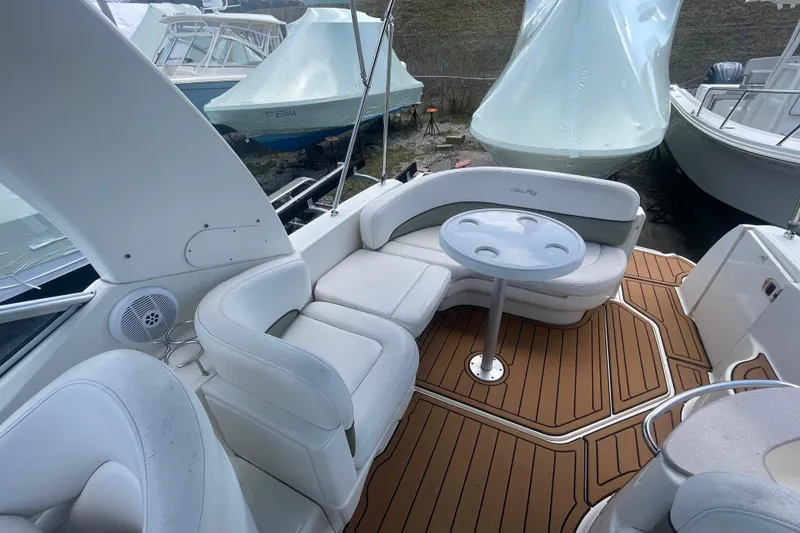 Slide: The Image of 2007 Sea Ray Sundancer 260 interior with white seating and wooden deck. - 8