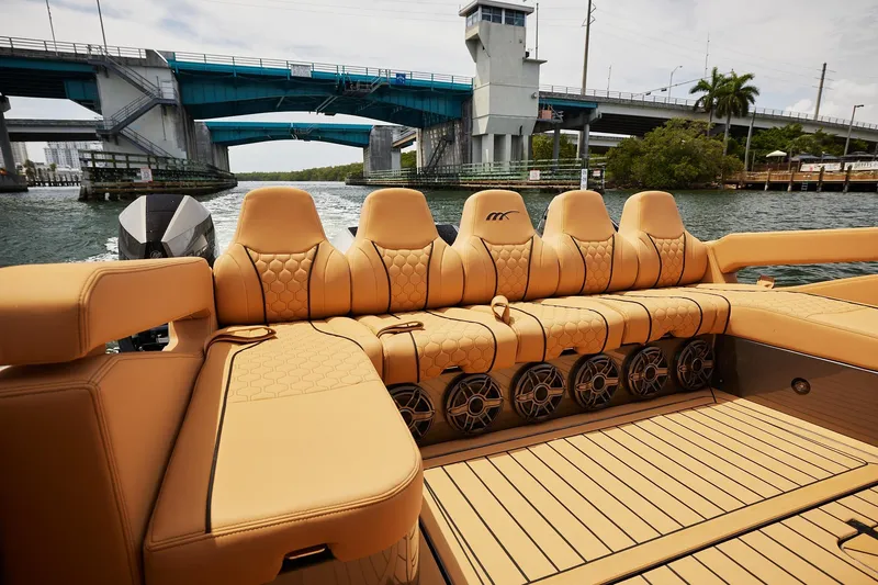 Slide: The Image of Luxurious seating on 2026 Midnight Express 52 Vitesse boat, under a bridge on a sunny day. - 37