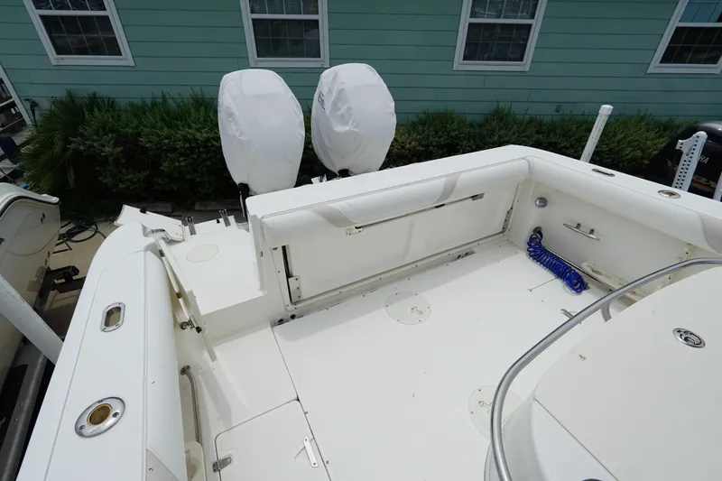 Slide: The Image of 2004 Boston Whaler 320 Outrage boat deck with covered engines and clean white interior. - 11