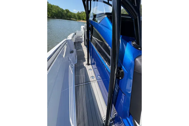 Slide: The Image of 2020 Nor-Tech 340 Sport Center Console boat, blue and white deck, on calm water. - 14