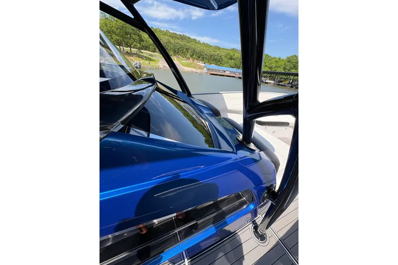 Slide: The Image of 2020 Nor-Tech 340 Sport Center Console boat with sleek blue design on a sunny day. - 23