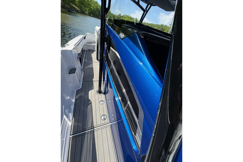 Slide: The Image of 2020 Nor-Tech 340 Sport Center Console boat with sleek blue exterior on a sunny day. - 24