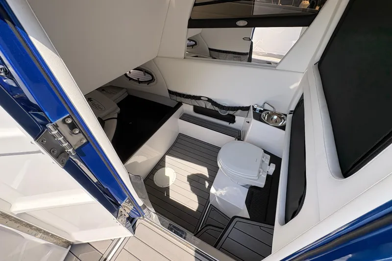 Slide: The Image of Interior of 2020 Nor-Tech 340 Sport Center Console, featuring a compact marine toilet. - 25