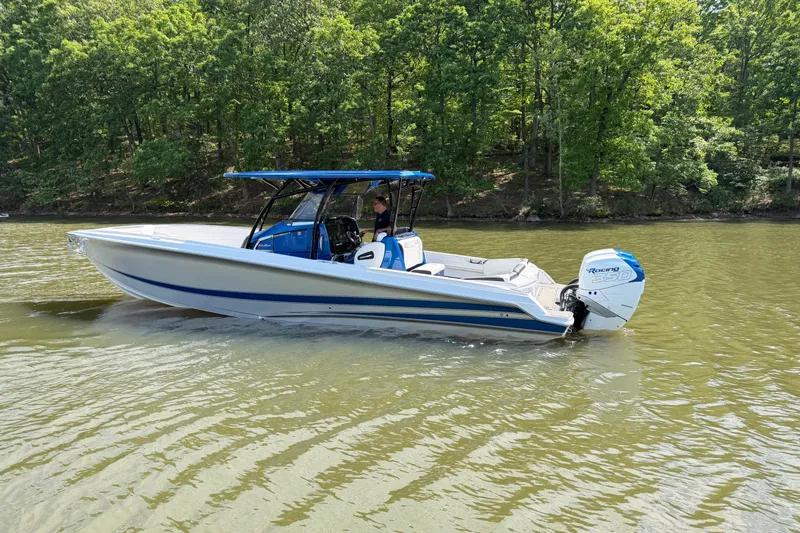 Slide: The Image of 2020 Nor-Tech 340 Sport Center Console boat on calm water, surrounded by lush greenery. - 3