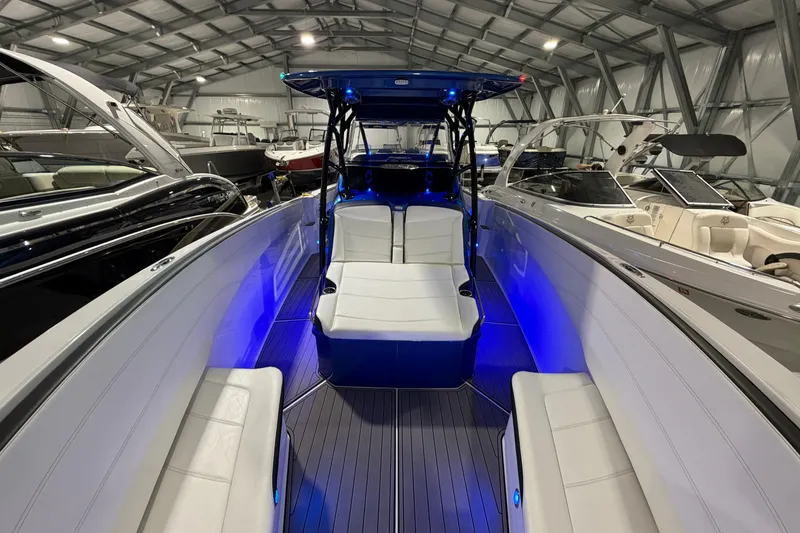 Slide: The Image of 2020 Nor-Tech 340 Sport Center Console boat with blue LED lighting in a showroom. - 34
